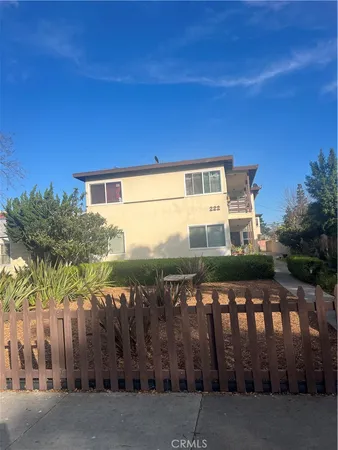 a view of a house with a wooden fence