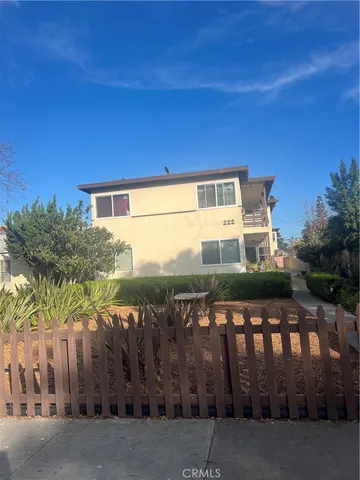 a view of a house with a wooden fence