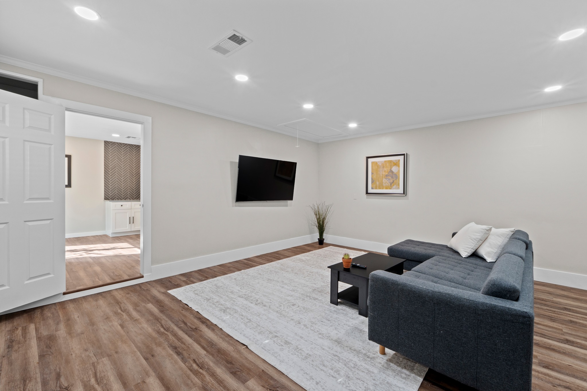 11811 Rotherham Drive Austin, TX 78754 - Photo 15 of 37 Laminated wood floors and recessed lighting enhance this versatile living space, perfect for relaxation or entertaining.