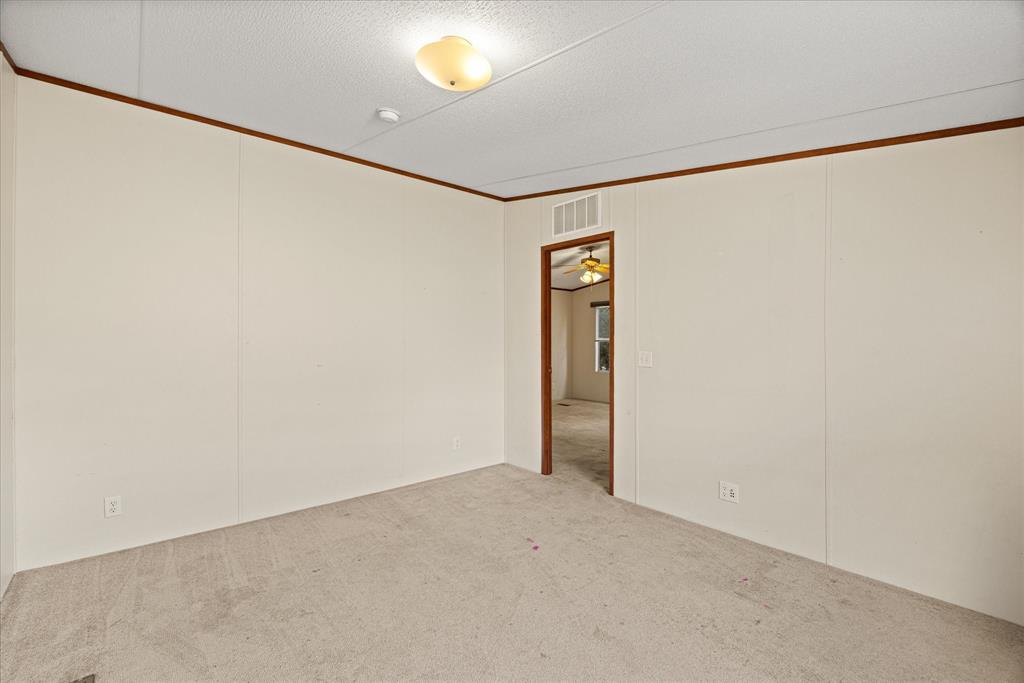 2903 Centaurus Way Granbury, TX 76048 - Photo 25 of 31 Carpeted spare room with crown molding, a textured ceiling, a decorative wall, and a ceiling fan