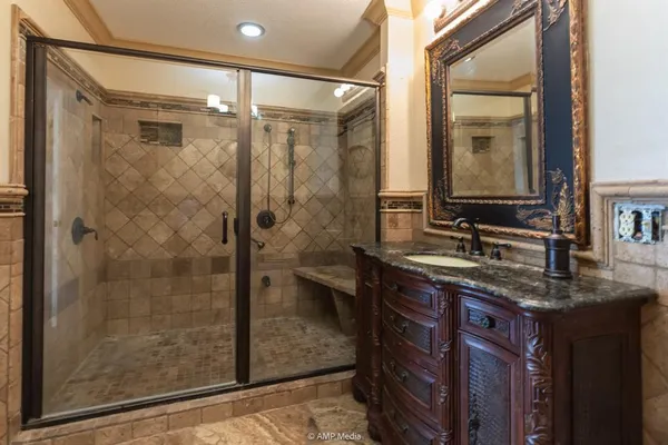 a bathroom with a granite countertop sink a mirror and a shower