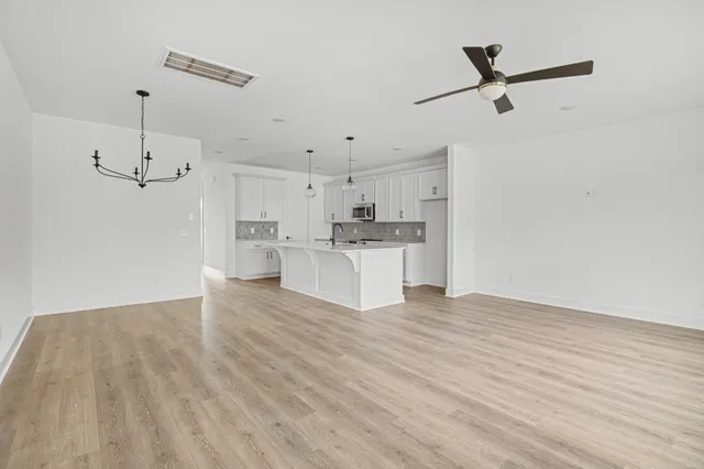 a view of a kitchen with wooden floor and a sink
