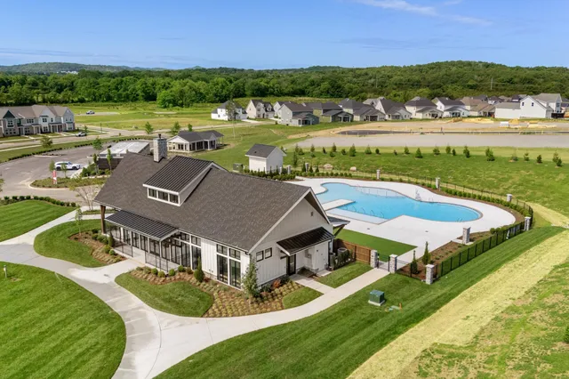 an aerial view of residential houses with outdoor space and ocean view