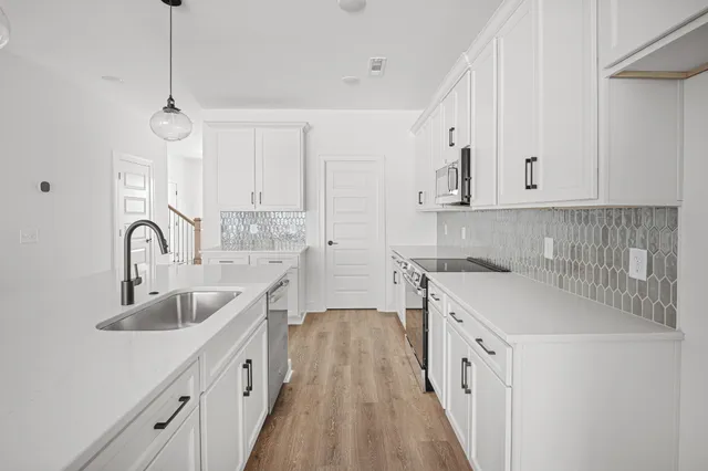 a kitchen with sink a stove and cabinets
