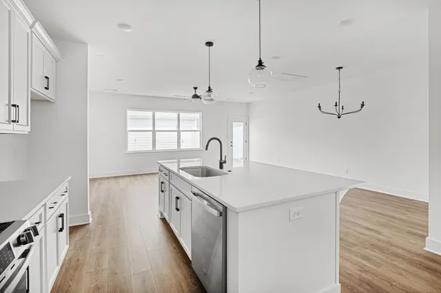a view of a hallway with wooden floor and a chandelier