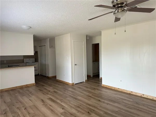 a view of an empty room with window and wooden floor