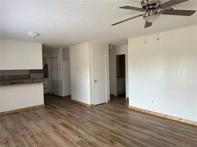 a view of an empty room with window and wooden floor