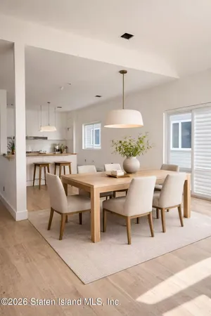 a dining room with wooden floor a chandelier a wooden table and chairs
