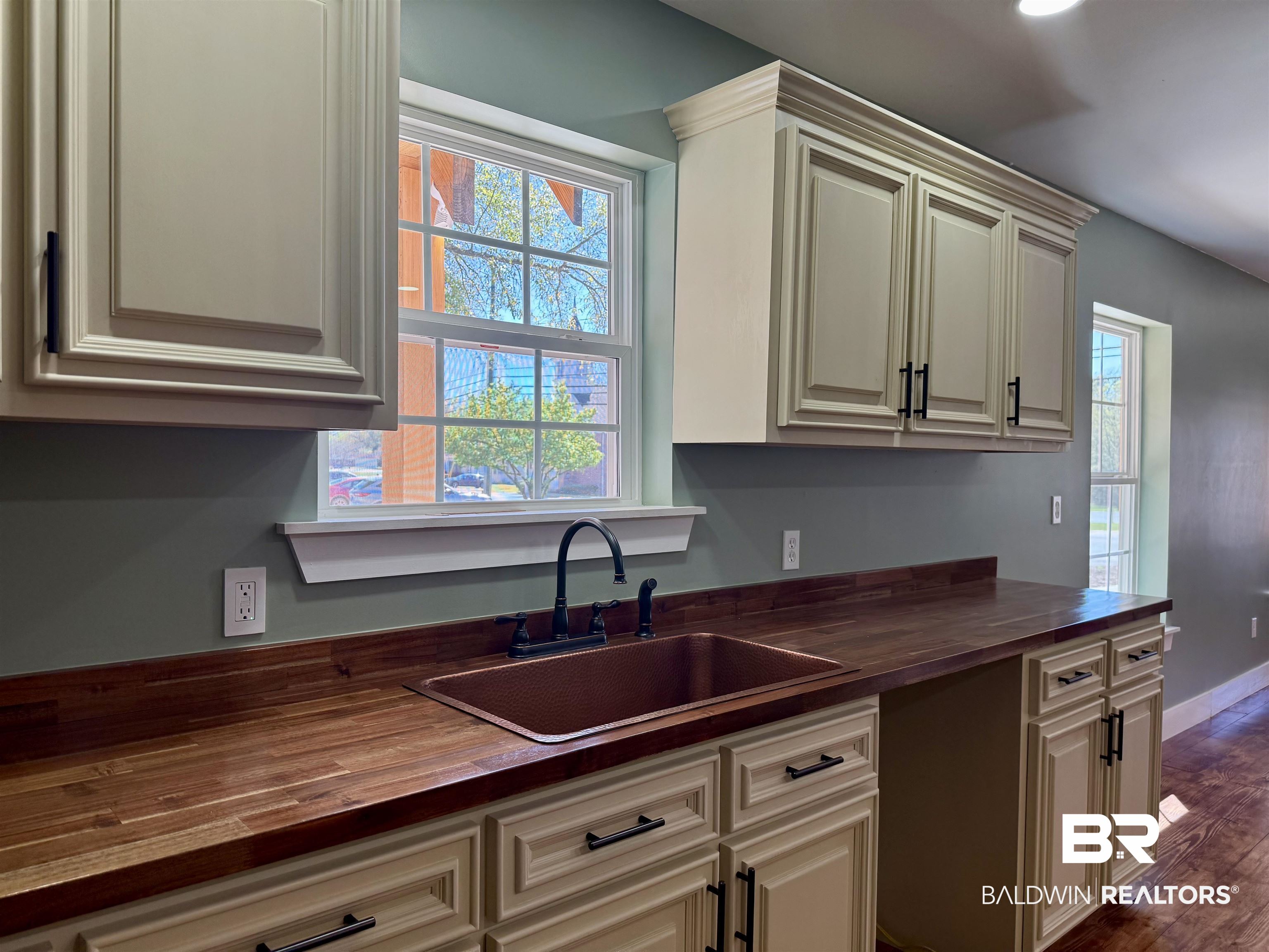 613 Forrest Avenue Brewton, AL 36426 - Photo 8 of 22 Kitchen with butcher block counters, healthy amount of natural light, cream cabinetry, and dark wood finished floors