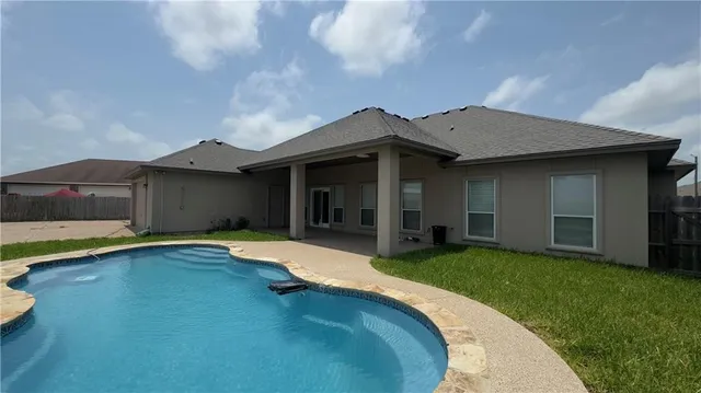 a view of a house with pool and a yard