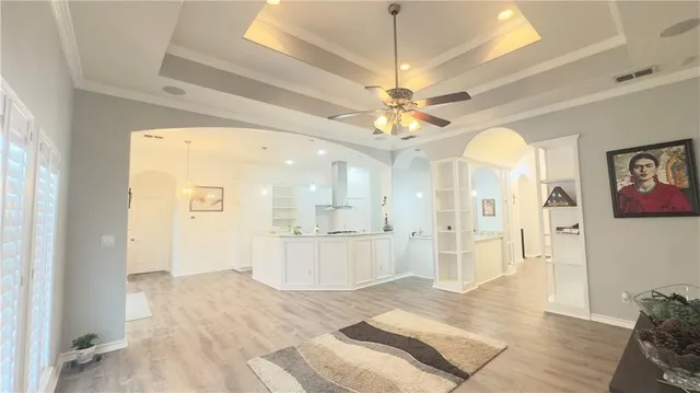 a view of a hallway with wooden floor windows and chandelier