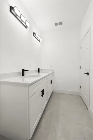a bathroom with a double vanity sink and mirror