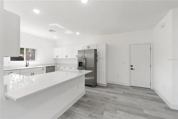 a large white kitchen with a large window