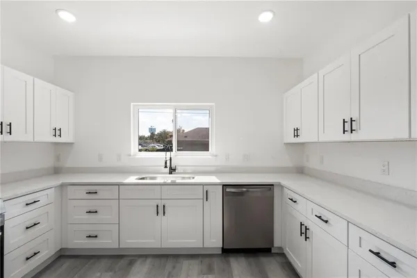 a kitchen with cabinets appliances a sink and a window