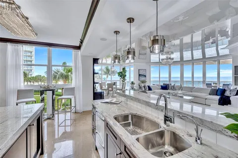 a kitchen with kitchen island a large counter top windows and stainless steel appliances