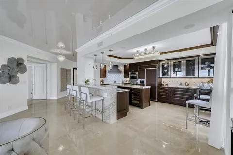 a large white kitchen with a large window and stainless steel appliances