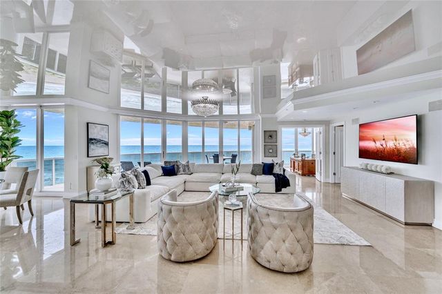 a living room with furniture a flat screen tv and a large window