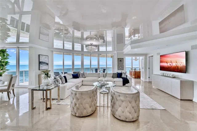 a living room with furniture a flat screen tv and a large window