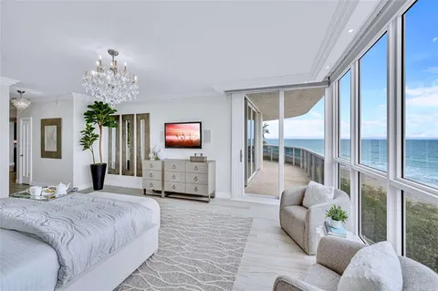 a spacious bedroom with a bed and a flat screen tv