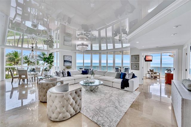a living room with fireplace furniture and a large window