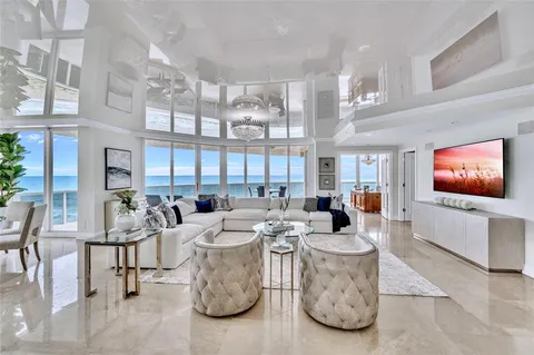 a living room with furniture a flat screen tv and a large window