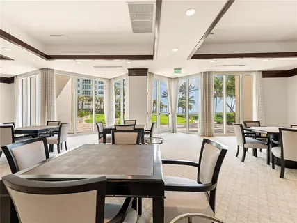 a dining room with furniture and large windows