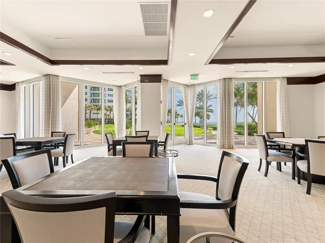 a dining room with furniture and large windows