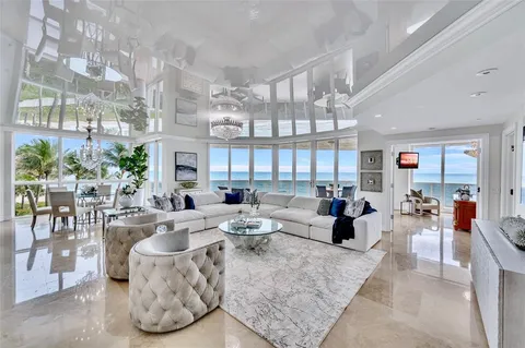 a living room with fireplace furniture and a large window