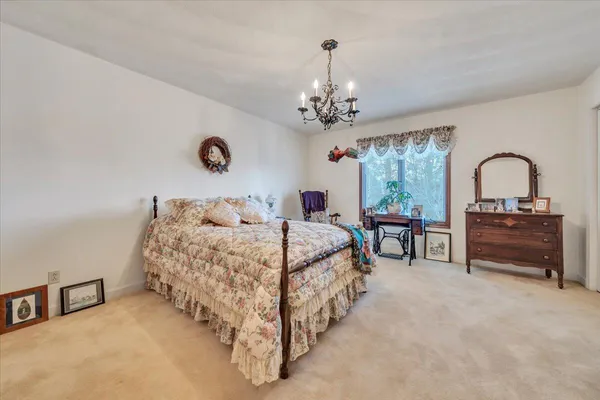 a spacious bedroom with a bed and a chandelier