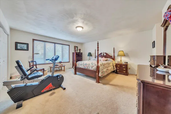 a spacious bedroom with a bed a couch and dresser