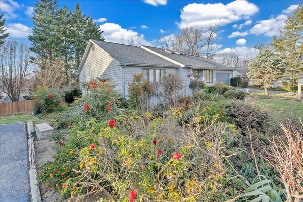 a front view of a house with a yard and fountain in middle