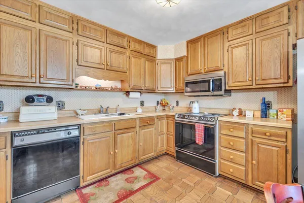 a kitchen with stainless steel appliances granite countertop a stove sink and cabinets