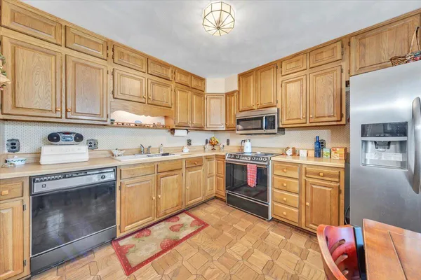 a kitchen with granite countertop a sink stainless steel appliances and cabinets