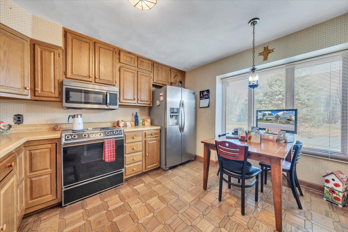 2409 South Clearing Road Salem, VA 24153 - Photo 9 of 45 a kitchen with stainless steel appliances granite countertop a stove top oven a sink dishwasher a dining table and chairs with wooden floor