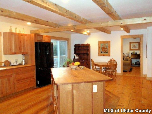 628 Buck Road, Unit STONE RIDGE Stone Ridge, NY 12484 - Photo 5 of 17 a kitchen with stainless steel appliances kitchen island granite countertop a refrigerator a stove and a cabinets with wooden floor
