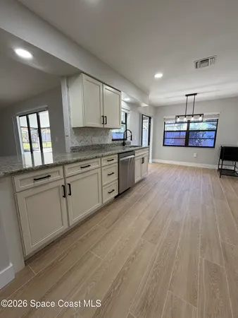 a large kitchen with stainless steel appliances granite countertop a sink and cabinets