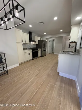 a large kitchen with kitchen island a sink stainless steel appliances and cabinets