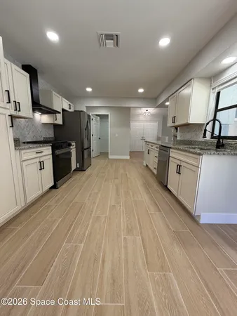 a large kitchen with granite countertop a stove and a sink