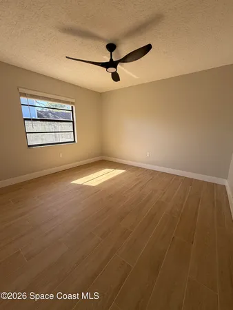 a view of empty room with ceiling fan and window