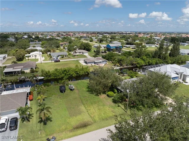 an aerial view of residential houses with outdoor space and trees