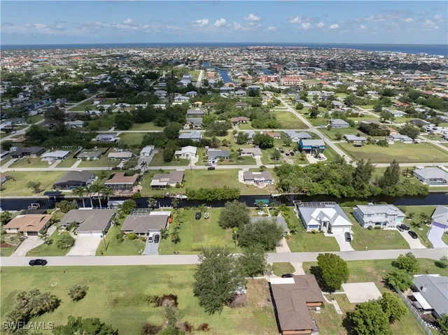 an aerial view of residential houses with outdoor space and lake view