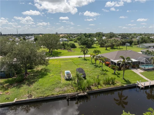 an aerial view of a house with a yard lake view and mountain in the back