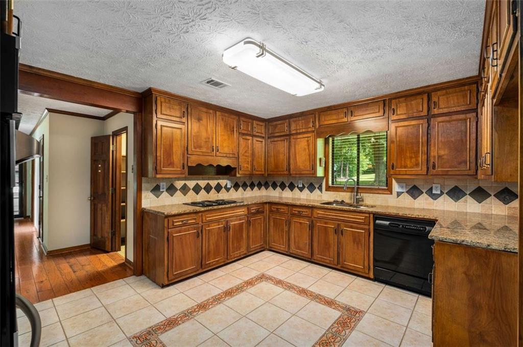1535 Pathfinder Way Southwest Lilburn, GA 30047 - Photo 12 of 58 a large kitchen with granite countertop a sink and cabinets
