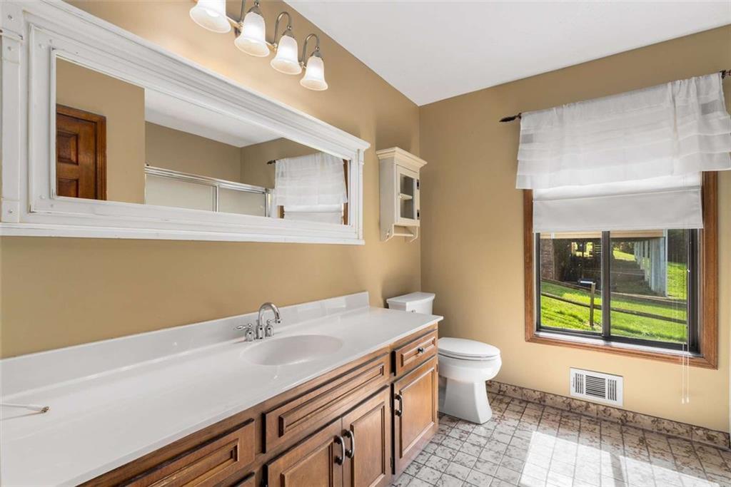 1535 Pathfinder Way Southwest Lilburn, GA 30047 - Photo 24 of 58 a bathroom with a sink a toilet and a large mirror