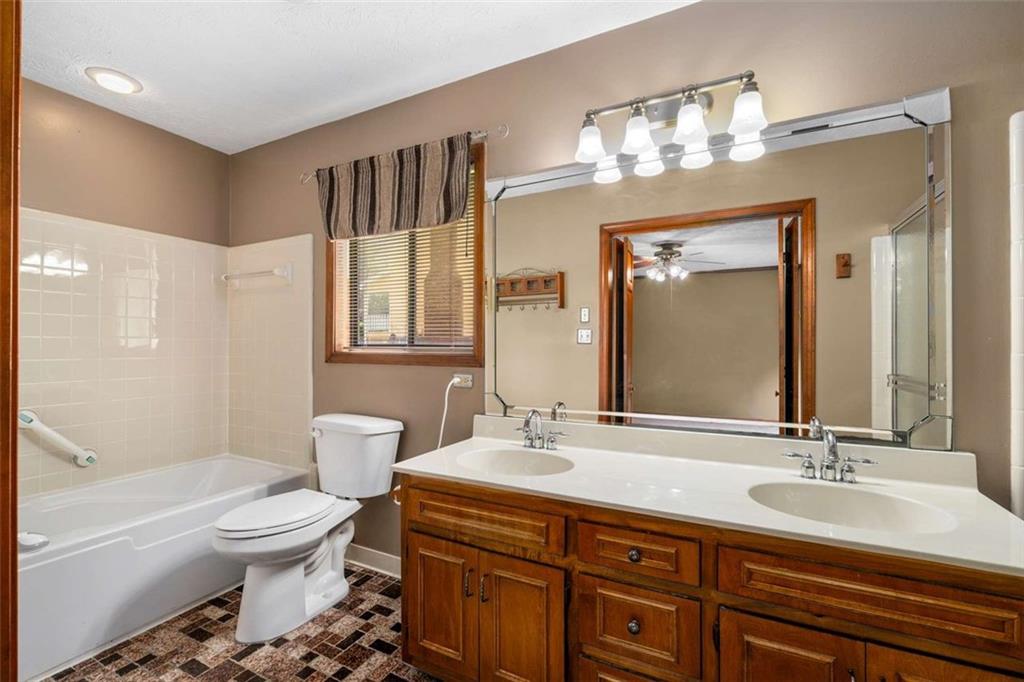 1535 Pathfinder Way Southwest Lilburn, GA 30047 - Photo 29 of 58 a bathroom with a double vanity sink toilet mirror and bathtub