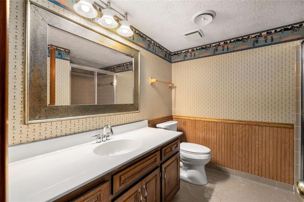 1535 Pathfinder Way Southwest Lilburn, GA 30047 - Photo 31 of 58 a bathroom with a sink a toilet a mirror and shower