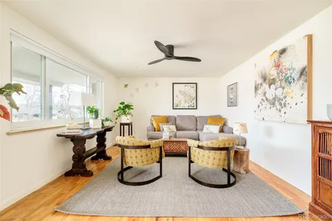 a living room with furniture a window and a painting on the wall