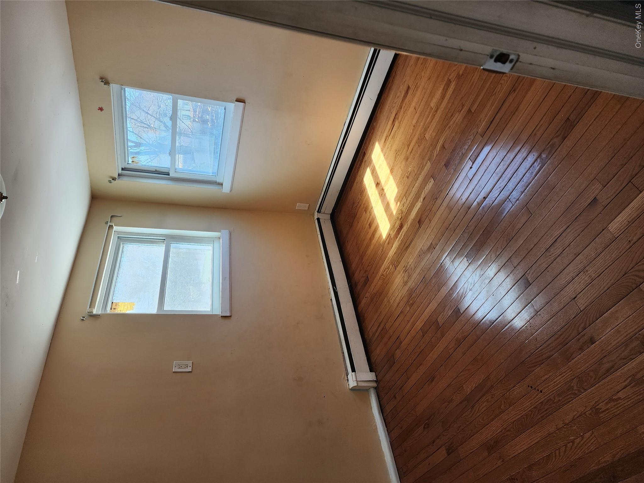 441 Morris Drive Valley Stream, NY 11580 - Photo 12 of 15 a view of an empty room with wooden floor and a window