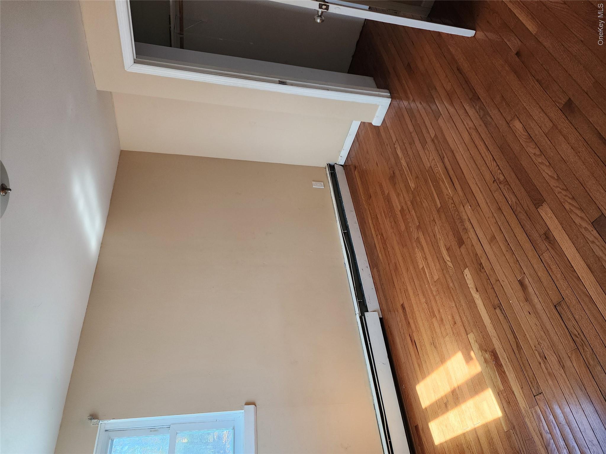 441 Morris Drive Valley Stream, NY 11580 - Photo 13 of 15 a view of an empty room with wooden floor and a window