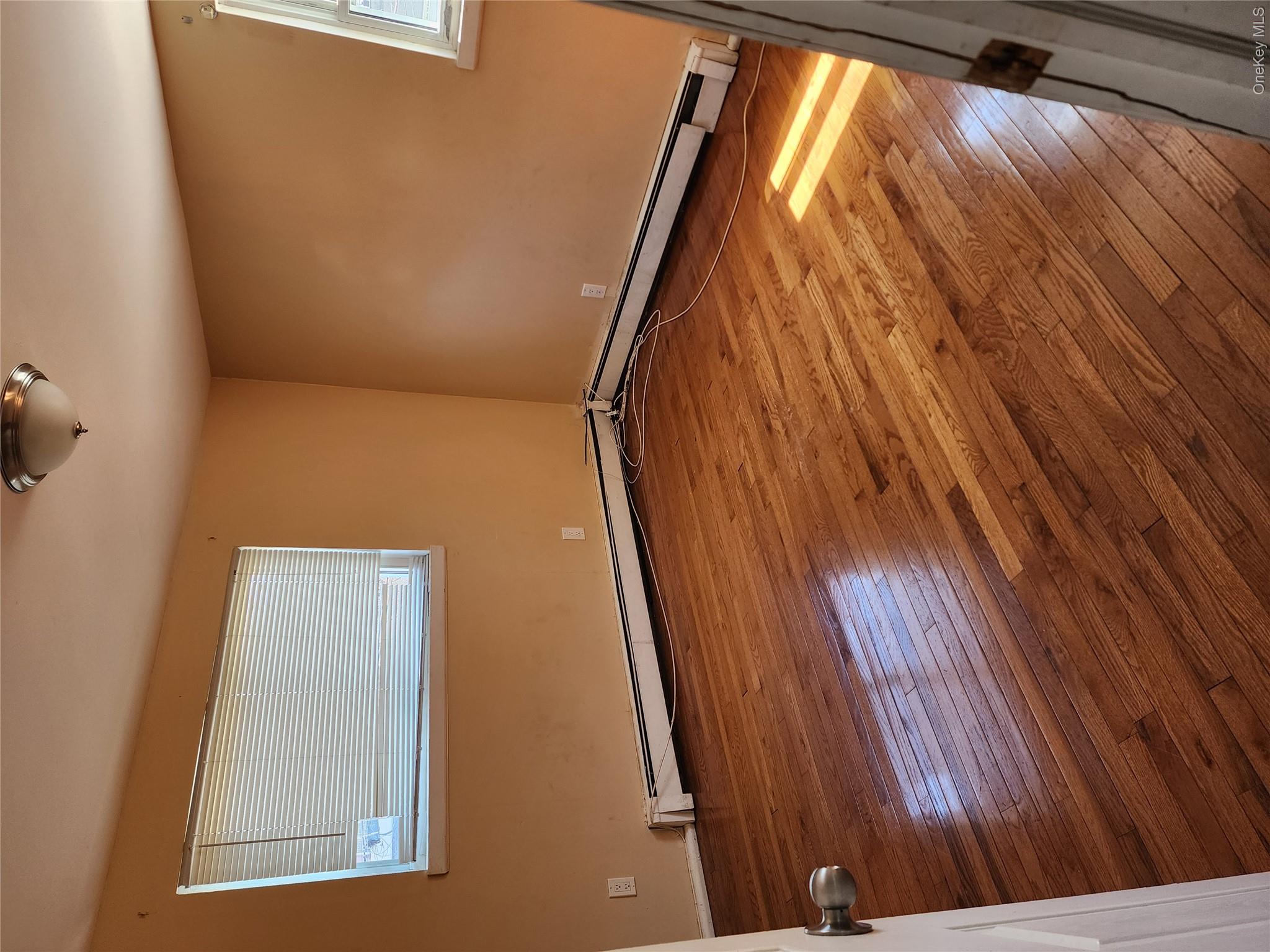 441 Morris Drive Valley Stream, NY 11580 - Photo 14 of 15 a view of an empty room with wooden floor and a window
